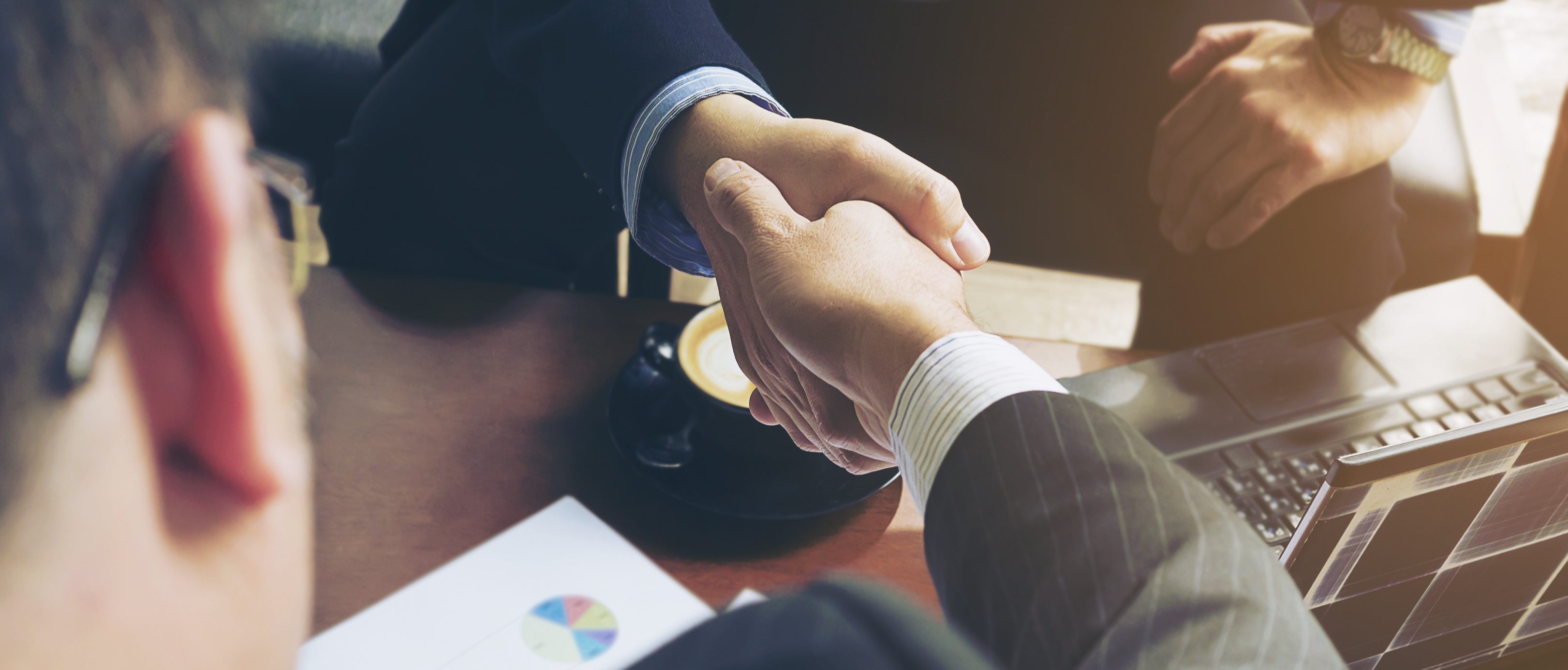 Two businessman shake hand in coffee shop