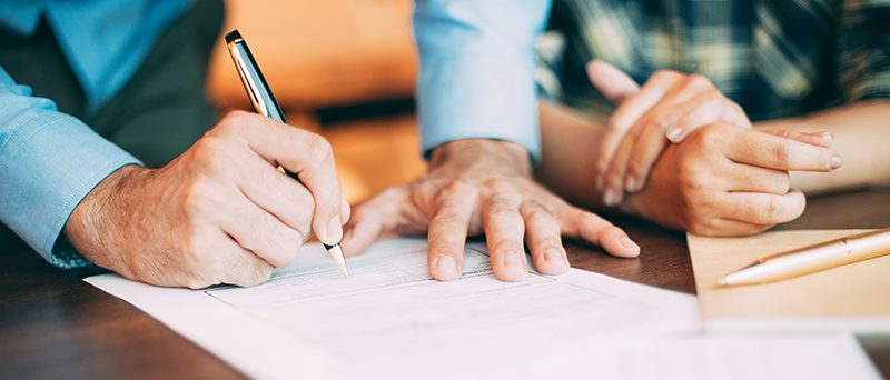 Senior candidate filling application form at table