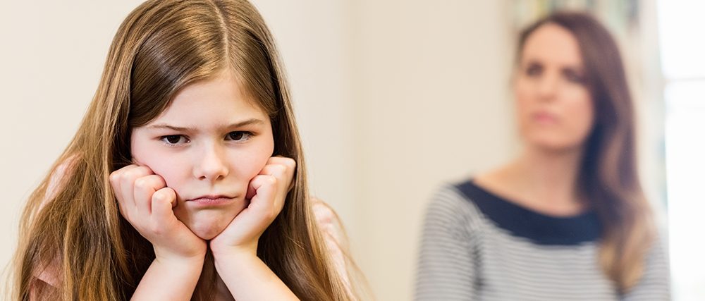 Daughter sitting upset with her mother in living room