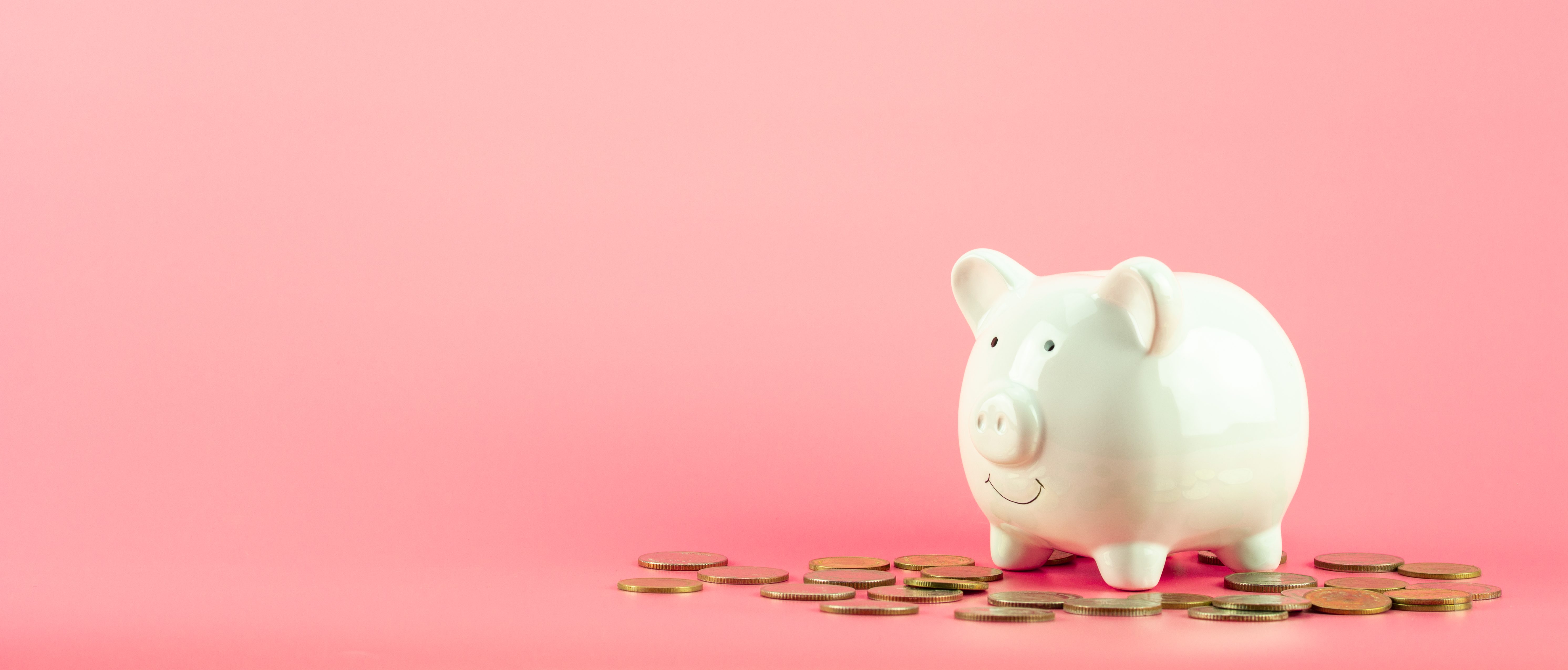 piggy bank and a golden coins pile on pink background. - save and management concept.