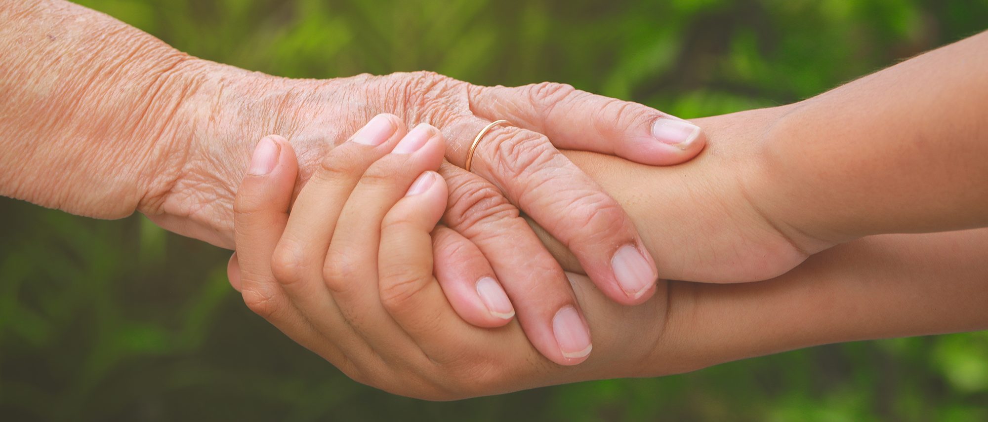 Old female hand holding young boys hands, care and support concept