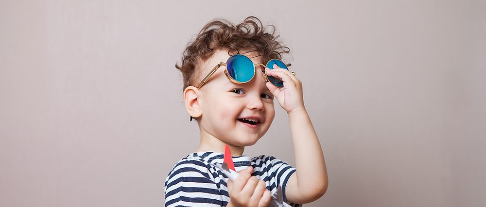 Infant, child with a toy airplane in his hands and sunglasses. Family law concept.